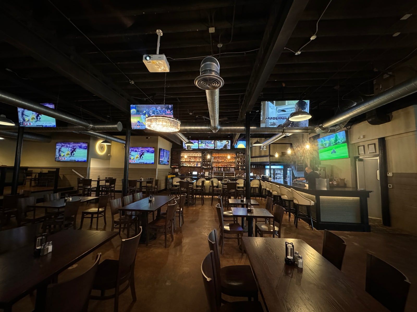 The Millstone Social dining floor with televisions mounted throughout the seating area, visible from every table.