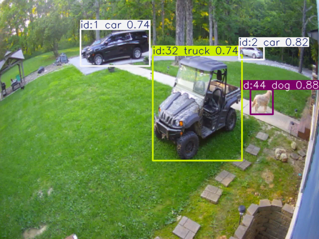 Another frame of the annotated stream with the dog boxed as dog 0.88 beside the utility vehicle boxed as truck 0.74